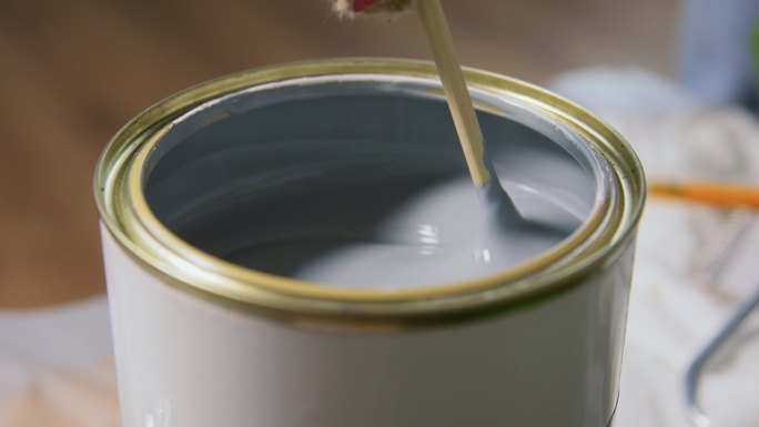 木棍搅拌罐中的灰色油漆