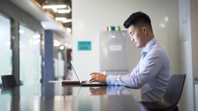 办公室年轻男性商务人士使用笔记本电脑办公