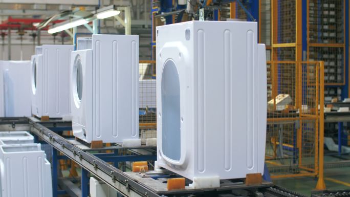 白色洗衣机机身在工厂的生产输送机上移动