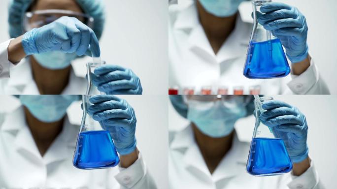研究人员在锥形瓶中搅拌亮蓝色液体