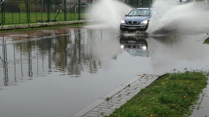 穿过被洪水淹没城市街道的汽车