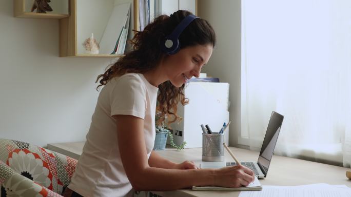 戴着耳机的年轻女性正在使用电脑