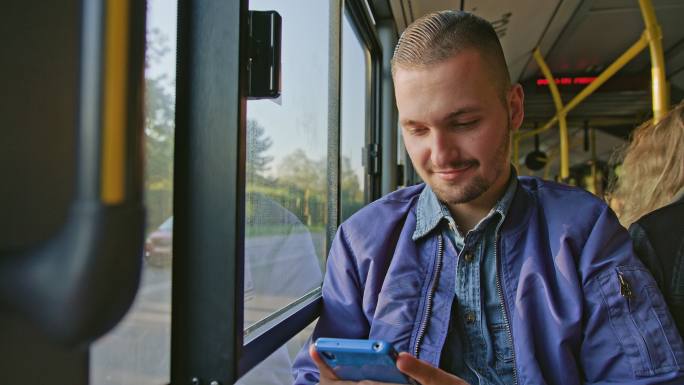 一个年轻人在公交车上使用智能手机