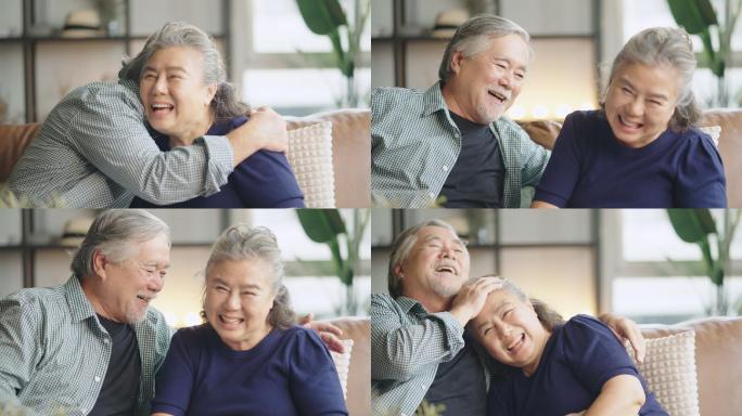 亚洲老年退休夫妇在沙发上谈笑风生