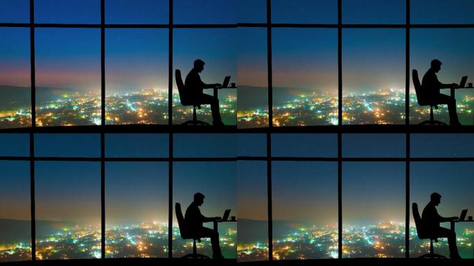 男人在夜市背景的窗户附近工作。