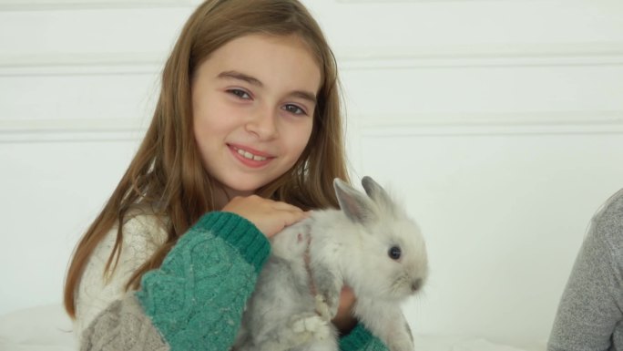 抱着兔子的小女孩萌宠灰色小兔