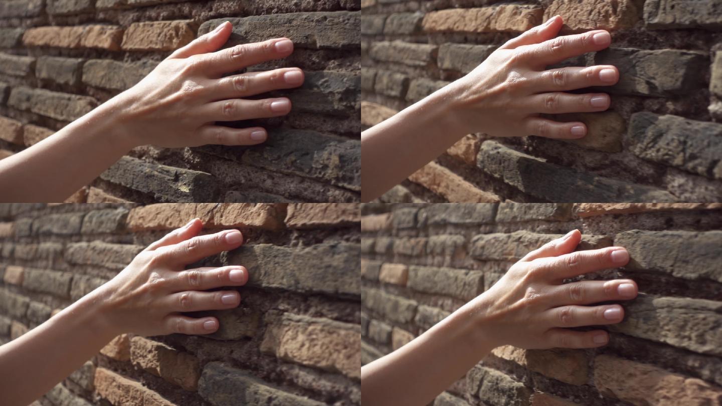 女性用手触摸石头粗糙的表面