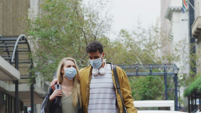 夫妇戴着防冠状病毒口罩在街上行走。