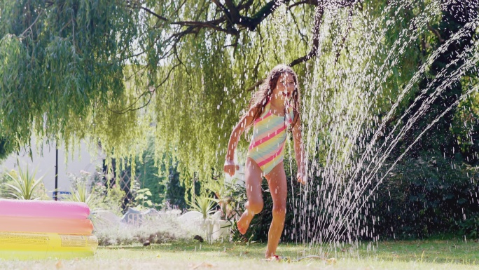 穿着游泳服的女孩在夏季花园里玩耍