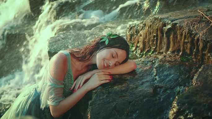 年轻迷人的女人躺在石头上。梦幻少女。