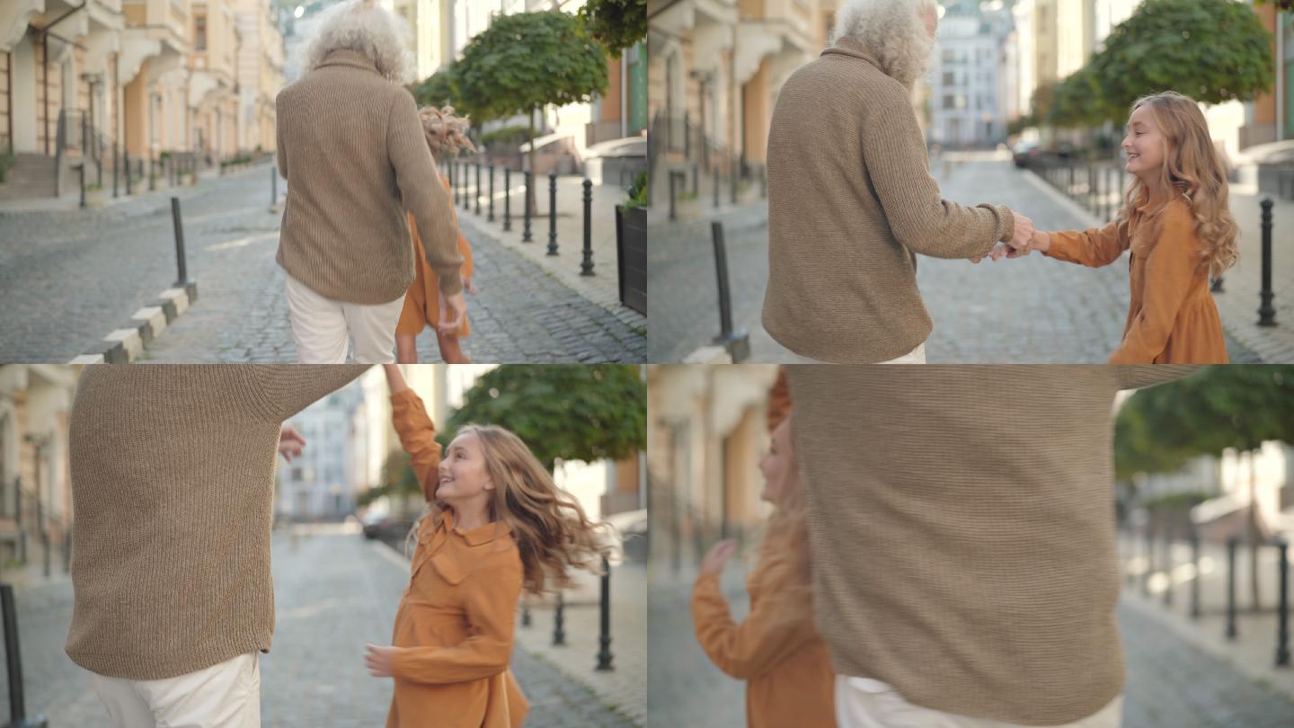 祖父和孙女在城市街道上散步和跳舞