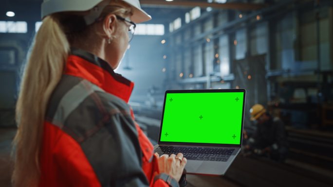 工程师使用带有绿色屏幕的笔记本电脑