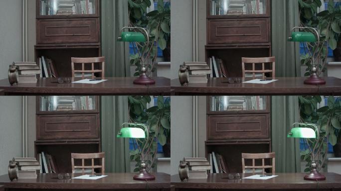书桌上有书、纸、眼镜和绿灯