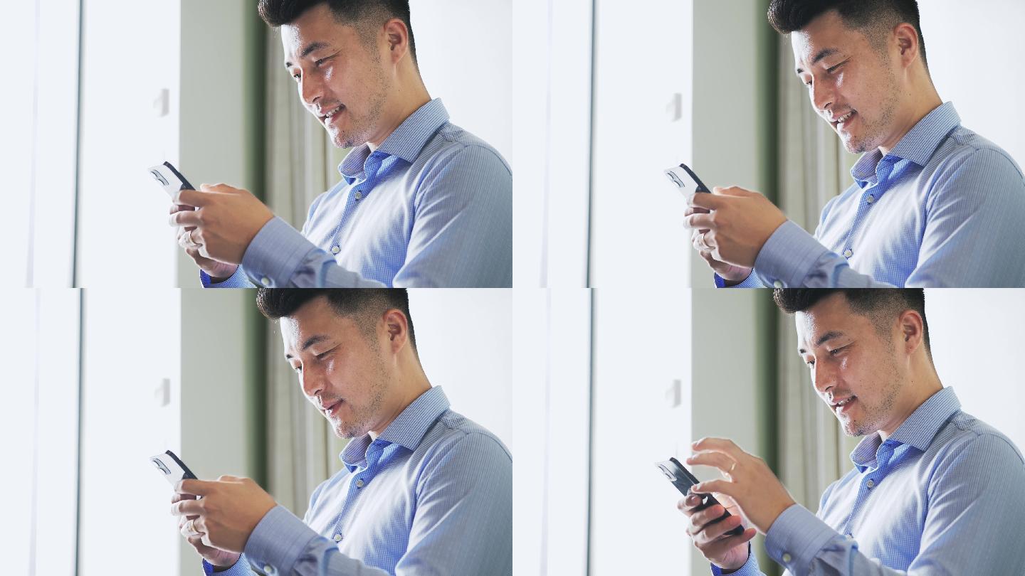 年轻男性在办公室使用智能手机回复信息