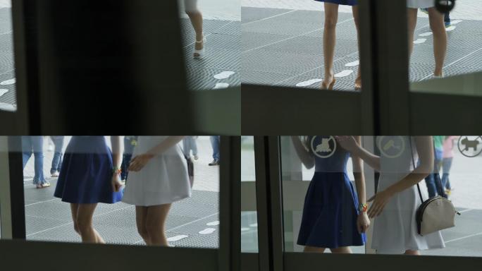 透过玻璃门观看欢乐的女孩来到购物中心