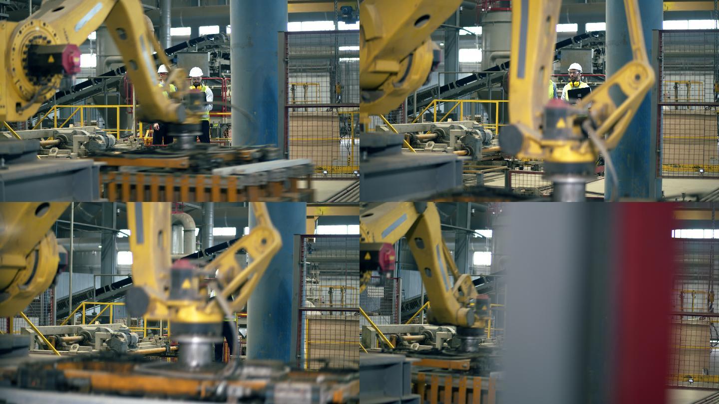 工厂同事站在一个设施里，而机器在工作。