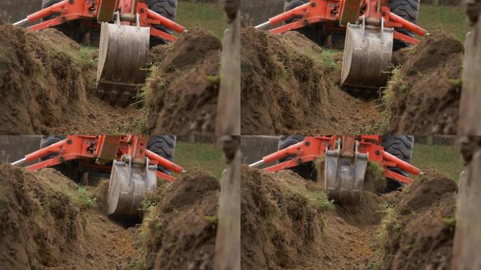 小反铲挖掘排水沟的低角度视图。