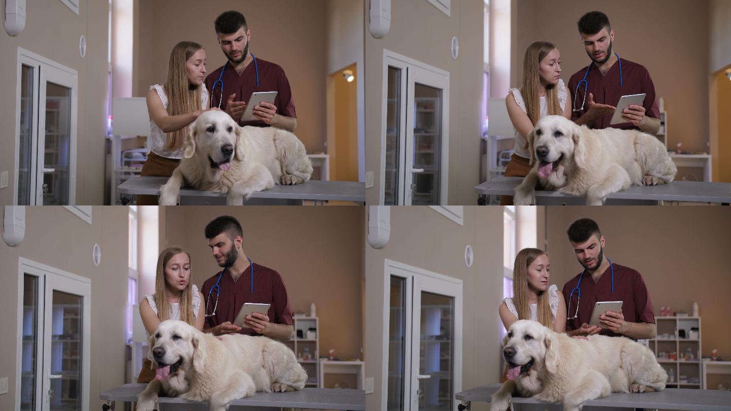 兽医在诊所用平板电脑与宠物主人交谈
