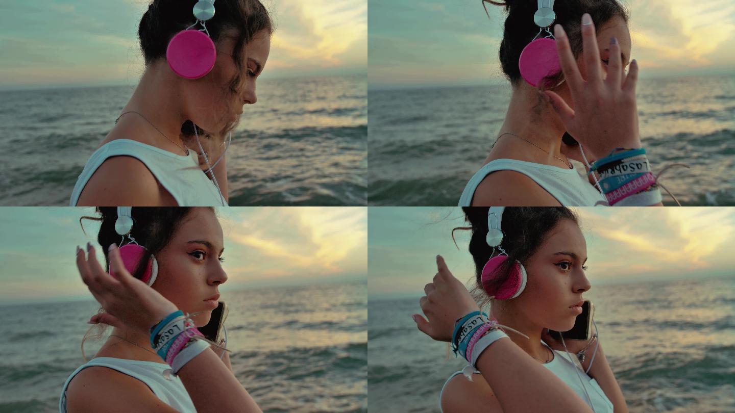 戴着耳机的少女在海滩上散步。