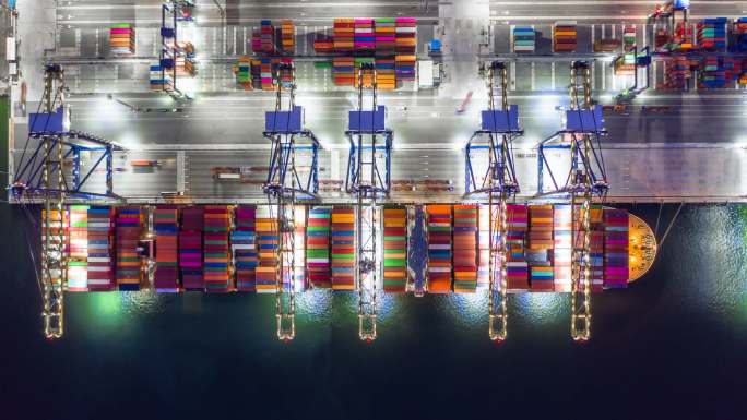 集装箱船夜间在港口装货，俯视集装箱船。