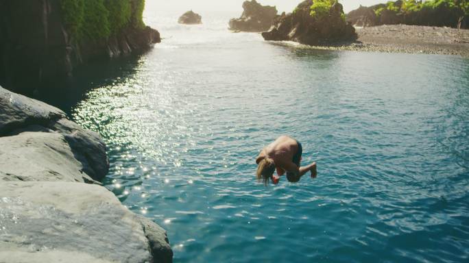 年轻人在海边做后空翻入海