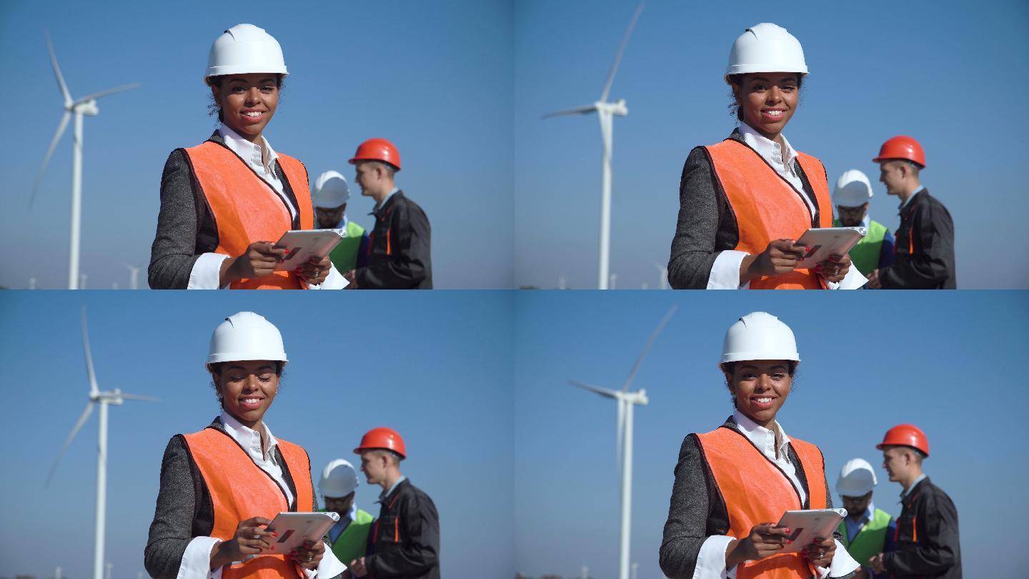 女工程师站在风力涡轮机前面