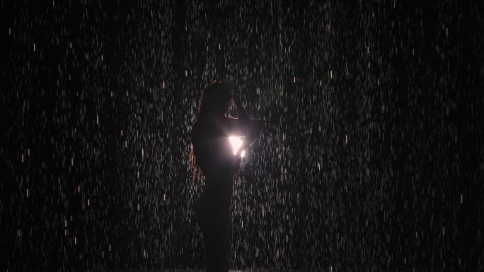 雨中的女人在明亮的聚光灯下表演舞蹈