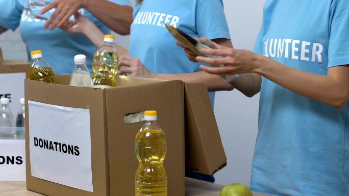 志愿者在社会中心工作将食物包装在捐赠箱中