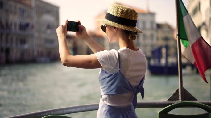 女性旅行者在威尼斯城的船上拍照