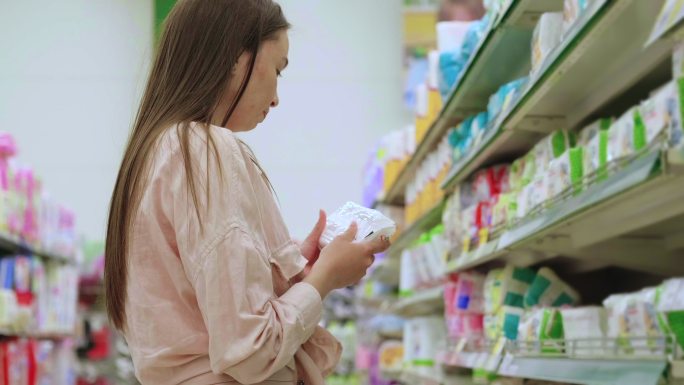 年轻女子在超市挑选婴儿湿巾