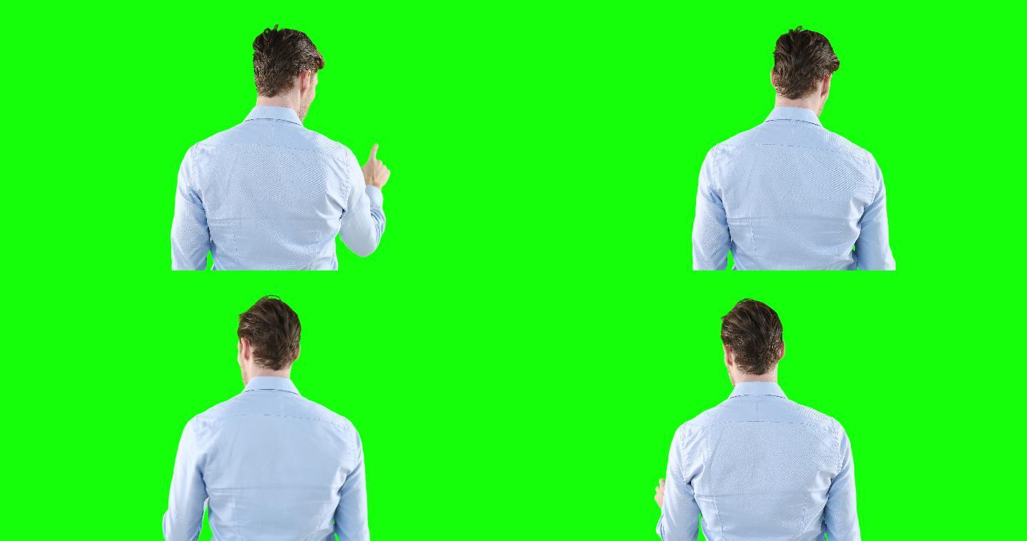 男子背对着绿色背景的摄像机