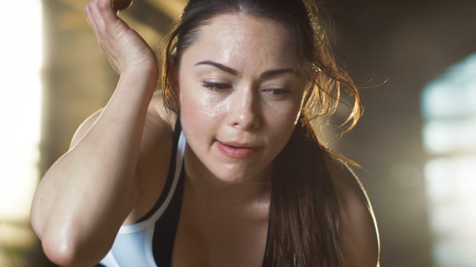 运动型女子用手擦去额头上的汗水