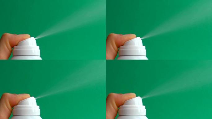 特写镜头在绿色背景上喷洒气溶胶除臭剂