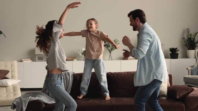 幸福的家庭夫妻和小女儿跳舞。