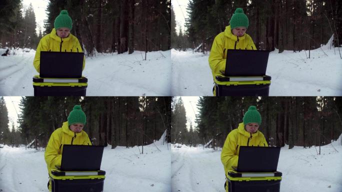 生态学家在冬季森林里用笔记本电脑工作
