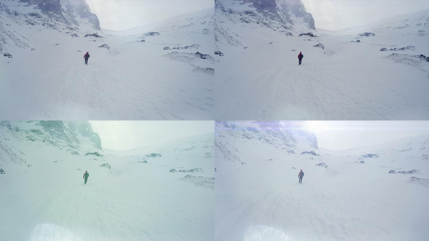 男子徒步穿越积雪覆盖的山谷，前往顶峰