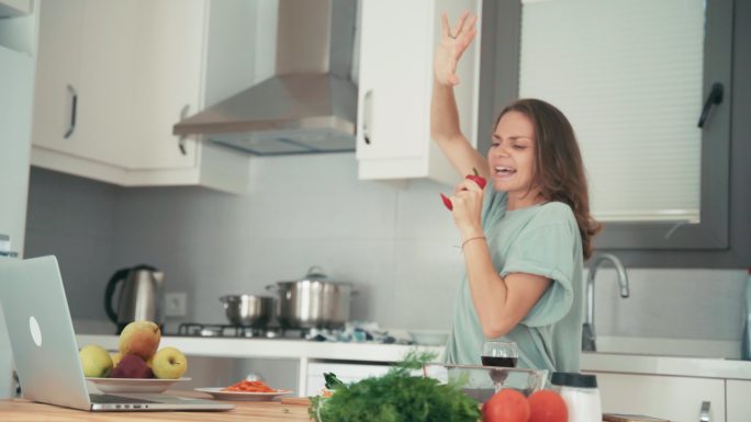 快乐的女性在厨房做饭时玩得很开心