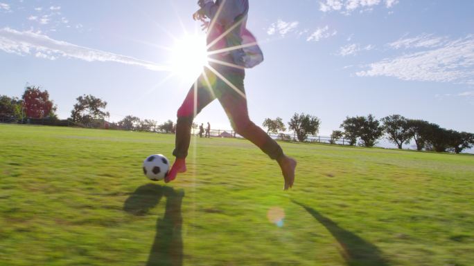 日落时分，四个年轻人在公园里踢足球