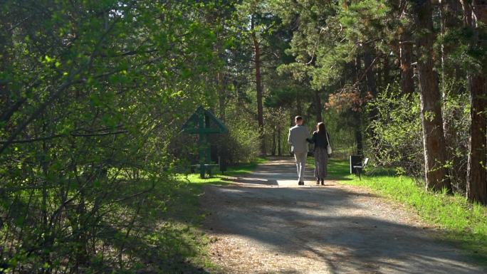 一对年轻夫妇漫步在一片美丽的森林中