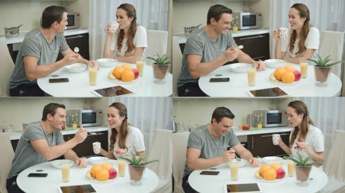 微笑的夫妇在现代厨房一起吃健康的早餐。