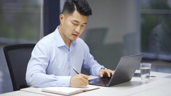 年轻男性商务人士办公室使用笔记本电脑办公