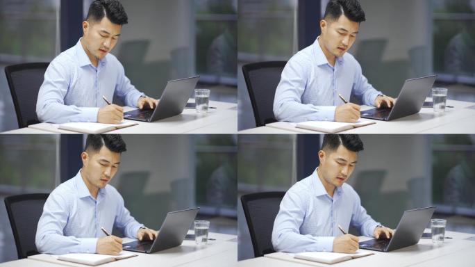 年轻男性商务人士办公室使用笔记本电脑办公
