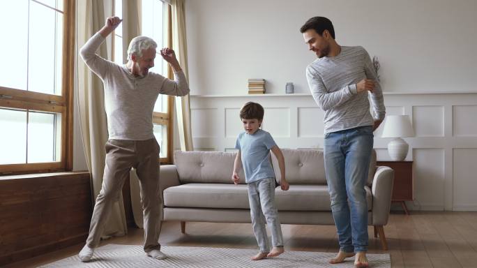 快乐的多代男性家庭在家跳舞