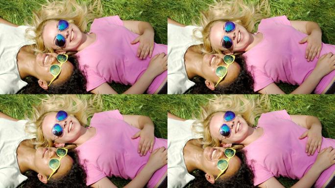 两个女孩在公园的草地上躺着