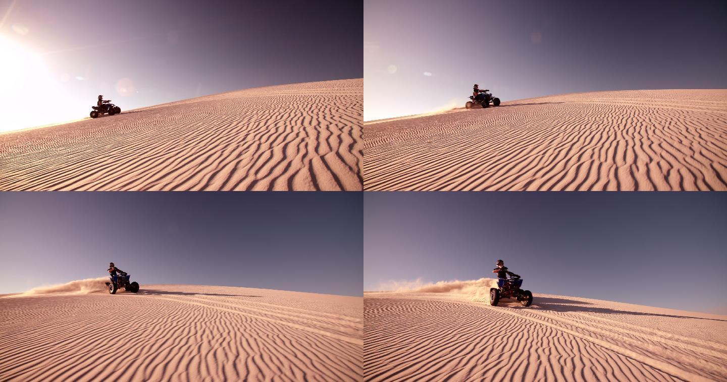 四轮摩托车手在沙丘上骑行
