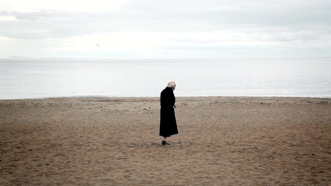 沙滩上走过的老人