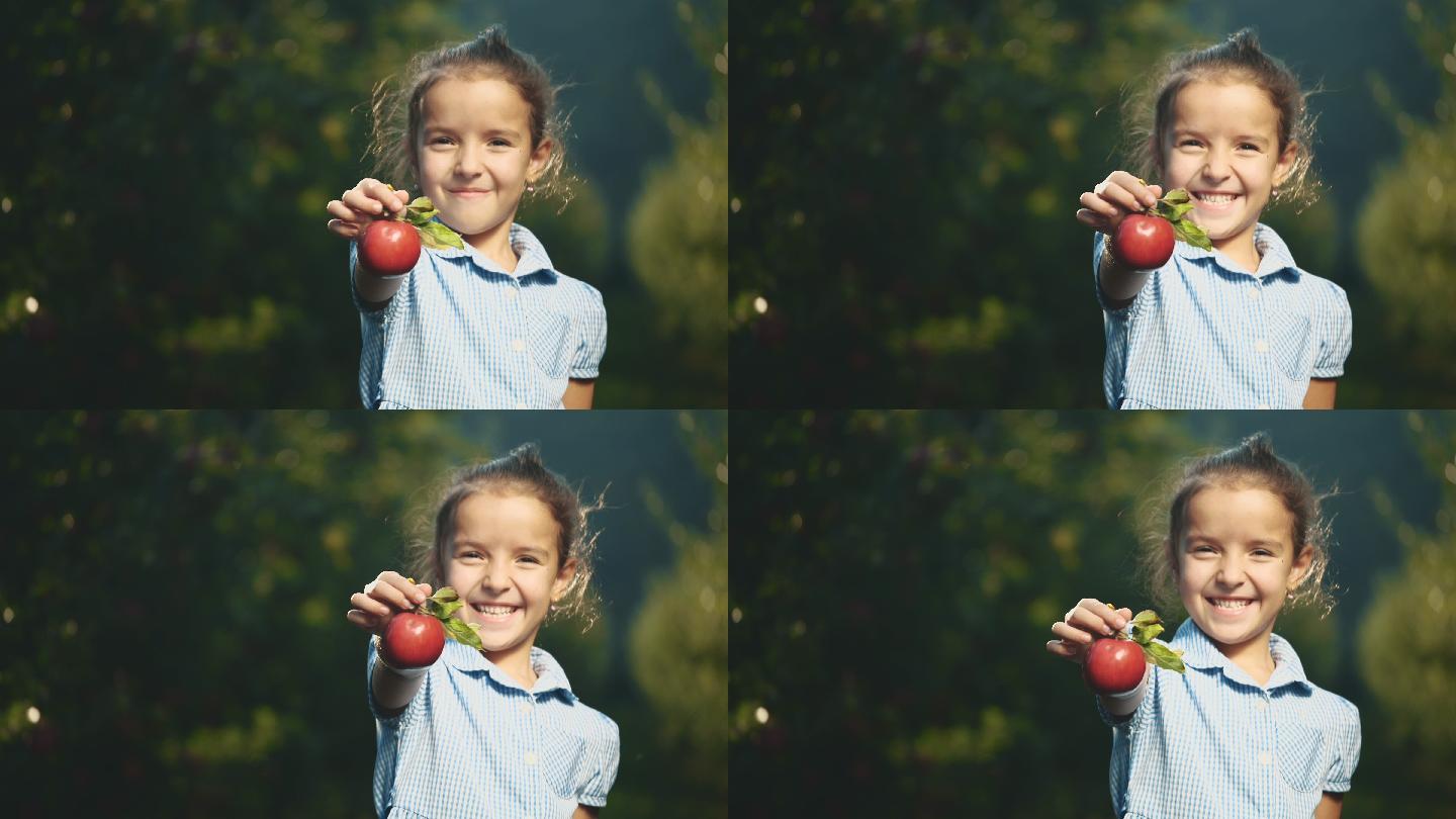 小女孩在户外献上一个红苹果