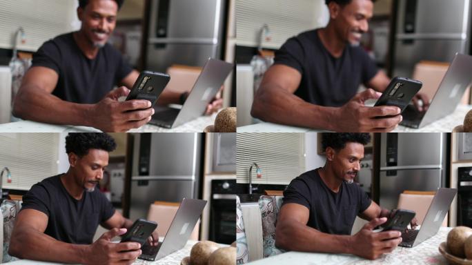 使用智能手机和笔记本电脑在家工作的男子