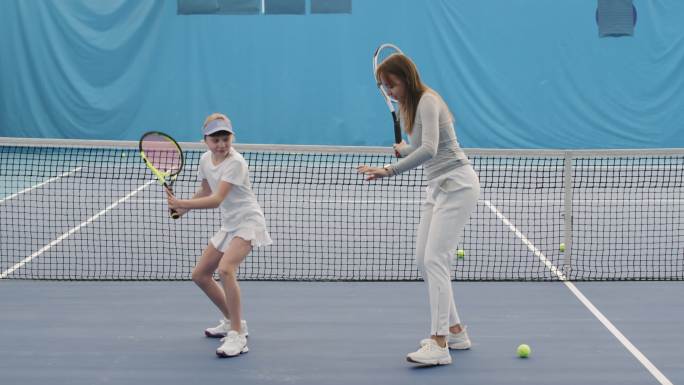 教练教小女孩如何用网球拍