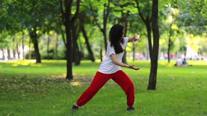 一名女子在公园里练习太极拳